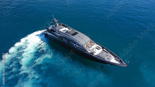 Aerial drone photo of modern yacht preparing to speed in Mediterranean port with deep blue sea © aerial-drone