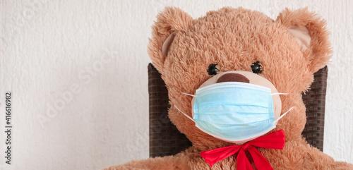 Teddy Bear wearing medical mask to emphasize the social aspect of self isolation and loneliness that happens when one is alone, lonely teddy bear. Panorama coronavirus covid-19 global pandemic Banner © Nodi