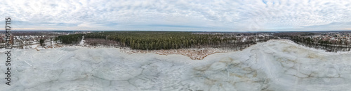 Panoramic view of a frozen lake in the spring during the thaw. Lake Titurgas in Balozi municipality