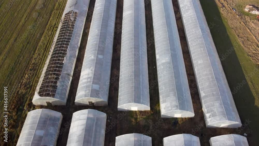 Aerial drone view of modern greenhouses. Agriculture. Plastic greenhouses on the field. Aerial drone view of modern greenhouses. Agriculture. Plastic greenhouses on the field.