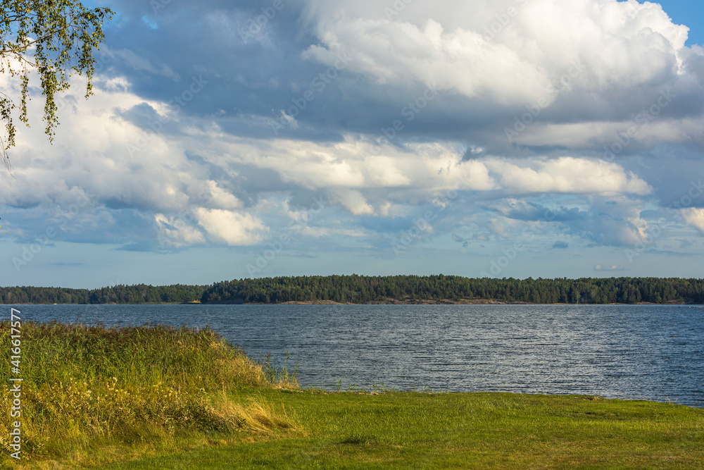 Beautiful natural Baltic sea landscape view. Green grass sea coast and calm water surface. Sweden.