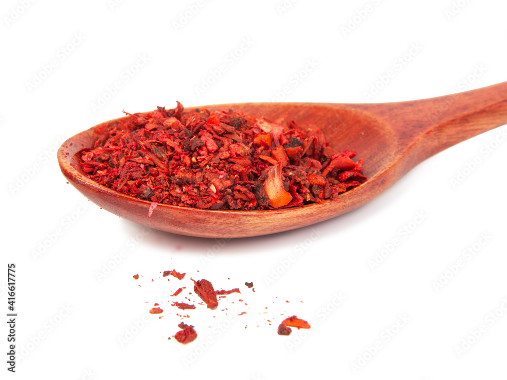 Dried tomato and paprika spice in wooden spoon isolated on the white background Dried tomato and paprika spice in wooden spoon isolated on the white background