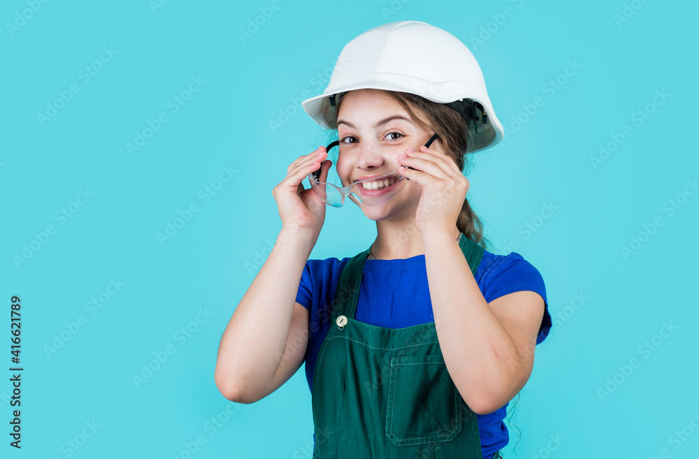 Mechanic at work. kid wear helmet on construction site. teen girl builder with building protective glasses. child on repairing work. concept of renovation in workshop. busy professional carpenter Mechanic at work. kid wear helmet on construction site. teen girl builder with building protective glasses. child on repairing work. concept of renovation in workshop. busy professional carpenter