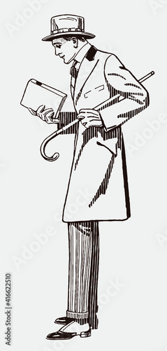 Stylish man from the early 20th century in side view, wearing hat and coat and holding a walking stick and a book