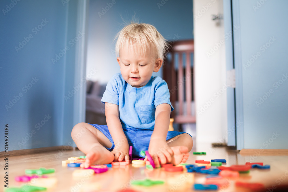 Fototapeta premium Cuter little toddler playing at home in the bedroom. 