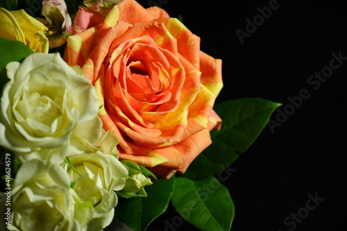 bouquet of red and yellow roses on black background