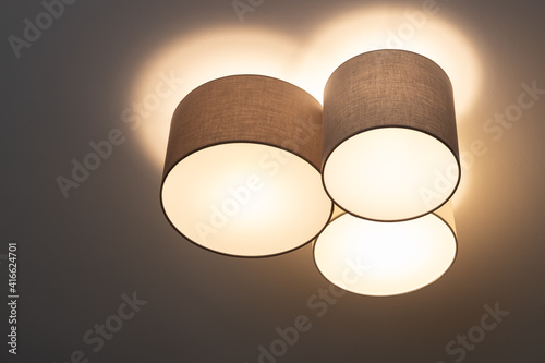 Wallpaper Mural A modern trendy ceiling lamp composed of a group of three cylinders, it shines with warm light. Interior decor details concept, lighting equipment. Scandinavian style. Horizontal Torontodigital.ca