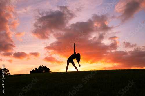 Female doing exercises stretching in a beautiful nature outdoor setting. 