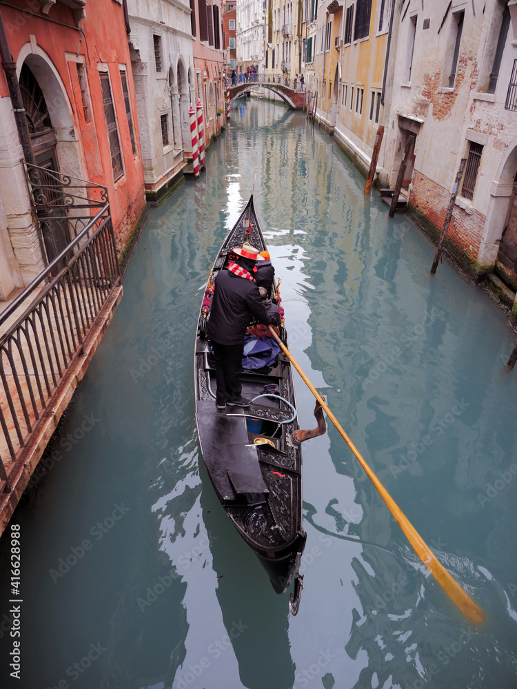Gondolier sails through the canals of Venice. Happy sea man carries a gondola around Venice, Italy.