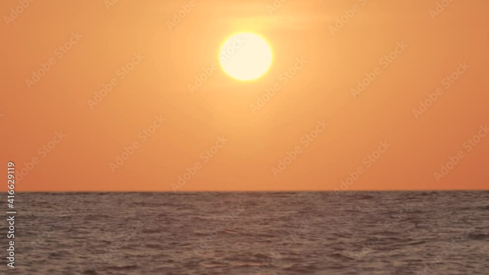sun and ocean with bird silhouettes flying by in slow motion sun and ocean with bird silhouettes flying by in slow motion