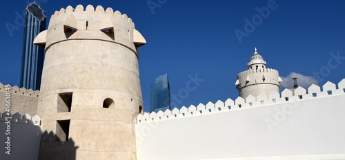 Alter Wachturm des inneren Forts hinter weißer Mauer vor strahlend blauem Himmel photo