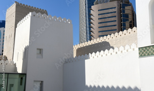 Verzierte Dach- und Mauerabschlüsse des Qasr Al Hossn vor Hochhaussilhouette photo