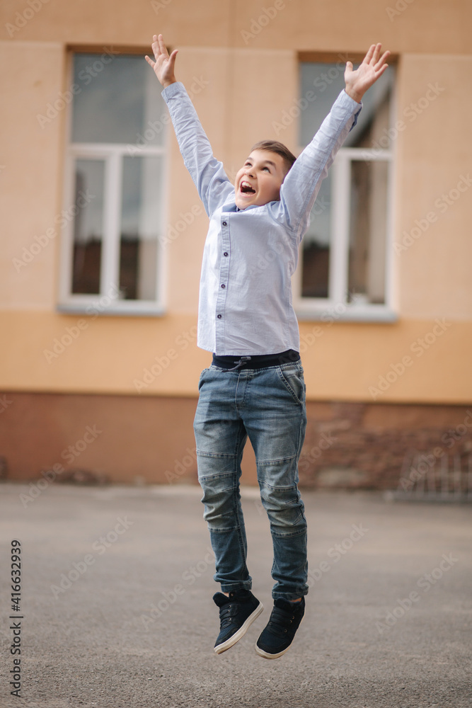 Happy schoolboy jump in the air. Happy boy finish school year