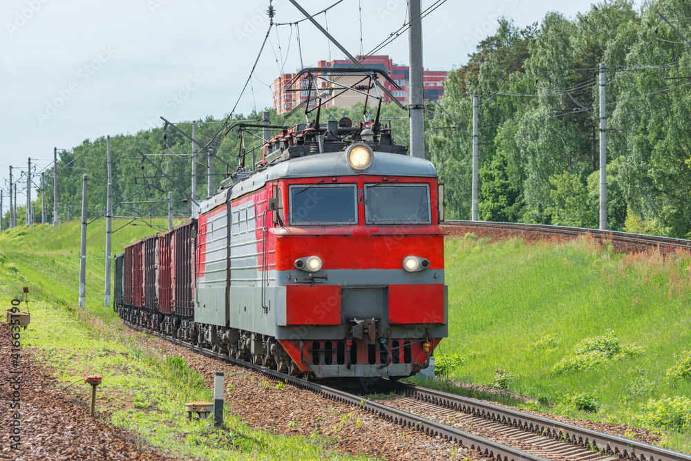 Fototapeta premium Long freight train approaches to the station.