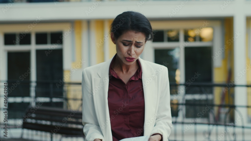 Disappointed mixed race woman feeling upset with project results outside. Disappointed mixed race woman feeling upset with project results outside.