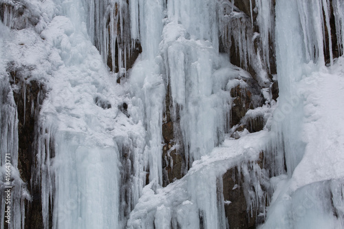 Closeup of thick layers of ice and icicles on rock in winter in Washington state  © Claudia