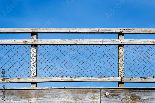 Weathered Wood and Chain Link Fence against a Clear Blue Sky