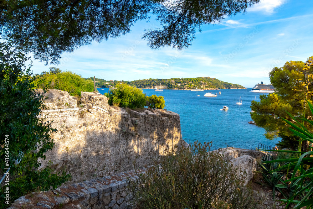 View from the castle fort at Villefranche-Sur-Mer, France, of the Mediterranean sea, hillls and luxury yachts in the water.