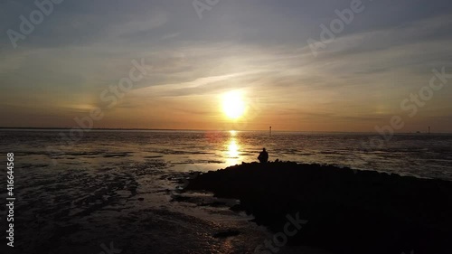 Weddewarden bei Bremerhaven im Watt mit der Drohne zum Sonnenuntergang, Landschaftsaufnahme am Wattenmeer, Gegenlicht mit Schatten und der Sonne photo