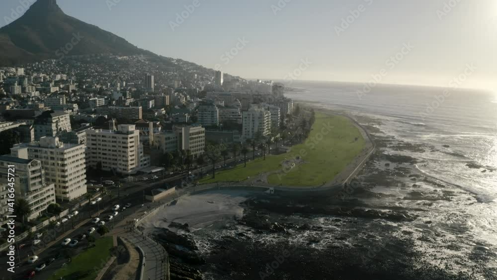 Aerial view of Cape Town, South Africa, with Green Point and Sea Point, Table Mountain, Lion's Head, Signal Hill and Devil's Peak on a bright and sunny day filmed in 4k with a drone