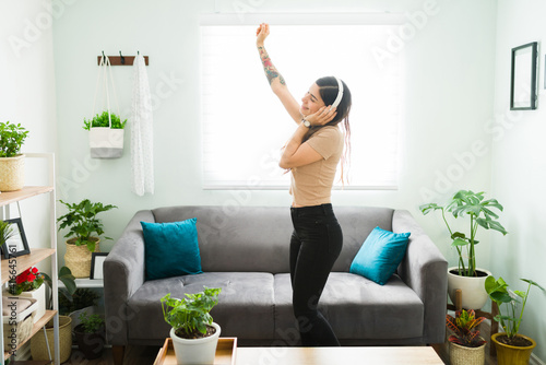 Excited young woman dancing and singing alone