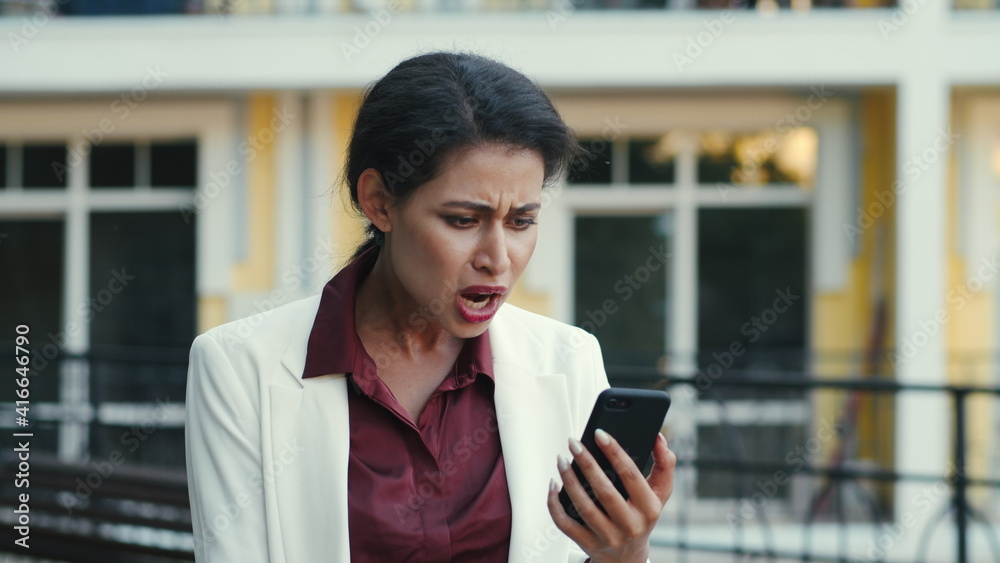 Fototapeta premium Disappointed businesswoman having video chat outside. Woman calling outdoors.