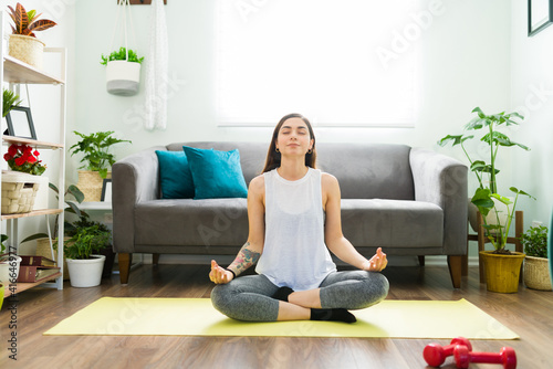 Hispanic woman meditating at home and feeling relaxed