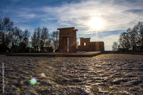 Madrid, Spain; March 7, 2019. Temple of Debod in the Parque del Oeste in Madrid. Ancient Egyptian temple with the sun in the background and clouds in a celestial sky. Ancient stone construction.