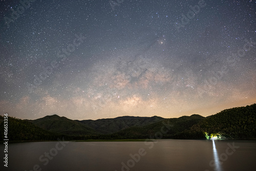 The stars and the milky way in the dark night sky are very beautiful.