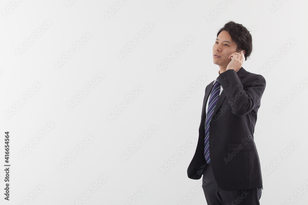A young Asian business man talking on his phone A young Asian business man talking on his phone