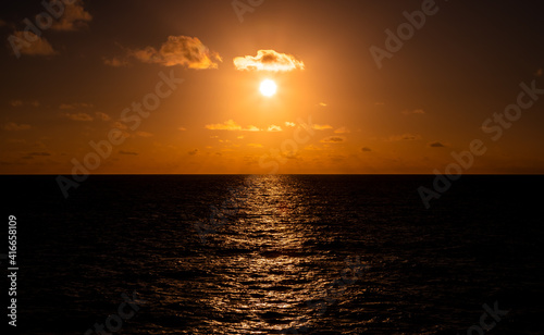 landscapes Beautiful refection orange,gold sunset with clouds over the  Pacific Ocean viewed from an ocean liner. © IKT224