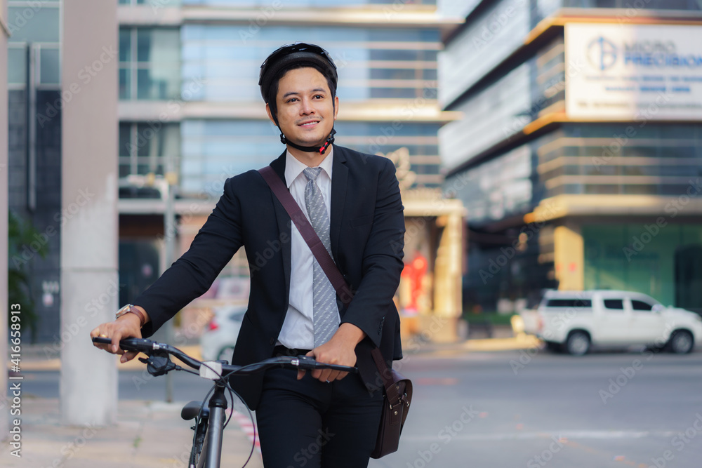 Asian businessman pushing his bicycle from home in the morning preparing to ride his bicycle to work. Eco tranportation.. Asian businessman pushing his bicycle from home in the morning preparing to ride his bicycle to work. Eco tranportation..