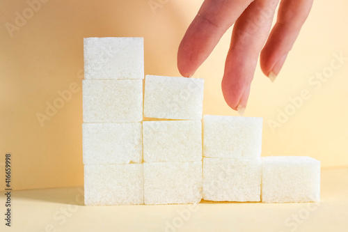 the fingers of the hand go down the stairs, which are lined with sugar cubes.