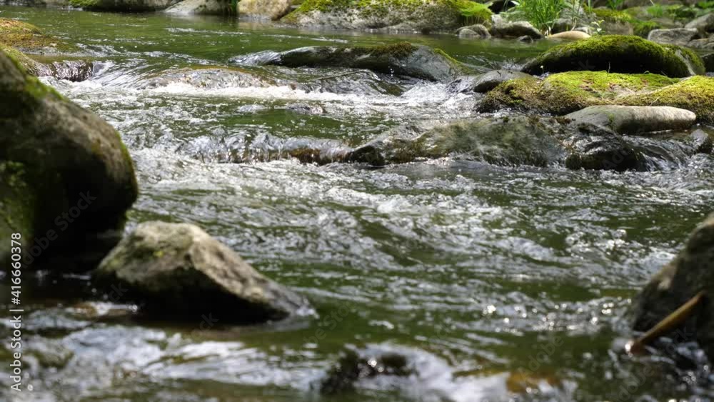 Fresh water flows down a beautiful waterfall in a creek in an austrian forest. Big rocks full of moss stand up out of the water. Fresh water flows down a beautiful waterfall in a creek in an austrian forest. Big rocks full of moss stand up out of the water.
