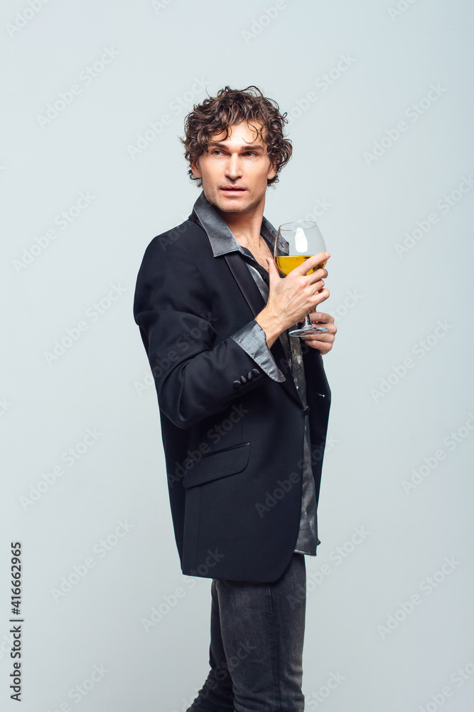 Confident young man in a jacket holding glass of wine over white background Confident young man in a jacket holding glass of wine over white background