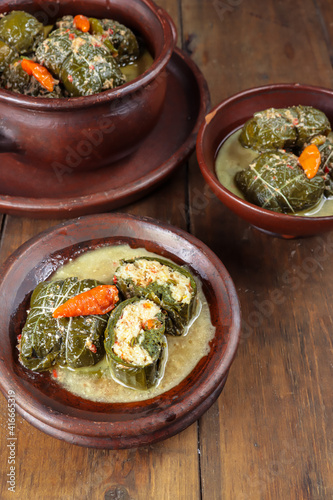 Buntil daun singkong is traditional indonesian food made from cassava leaves Stuffed with grated coconut, petai cina, and anchovy fish. Served on traditional plate photo