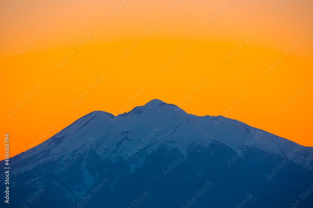オレンジに染まる雪の岩木山