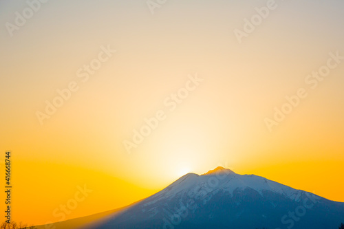 夕焼け 太陽が岩木山に重なる
