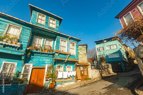 Photography Street in historic quarter Eminonu in Fatih district of Istanbul in Turkey with old poor decrepit wooden houses decorated with potted flowers in sunny winter day, photo of 2021