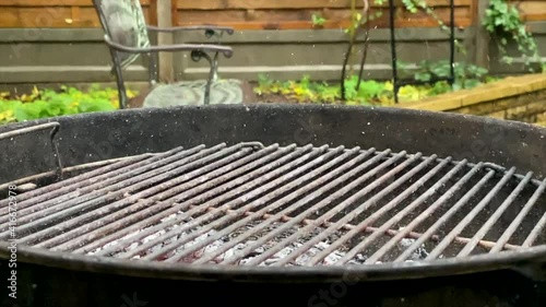 Pieces of ash fly over the hot barbecue brazier.Slow motion.