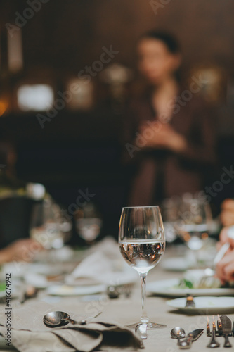 people eating in a restaurant.wine glass close up on table background