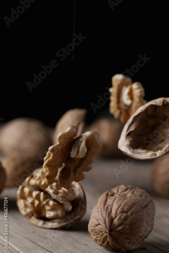 vintage background with walnuts in shell on a cracked wooden board