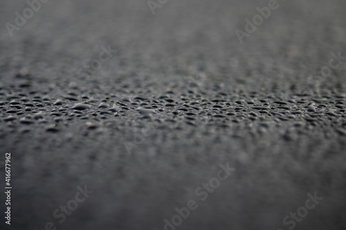 Water droplets on the metal surface in black color in close-up view, selective soft focus.