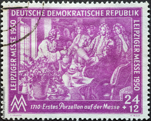 GERMANY  DDR - CIRCA 1950  a postage stamp from Germany  GDR showing the demonstration of the first Meissen porcelain at the Easter fair in 1710 by Johann Friedrich B  ttger. Leipzig Spring Fair