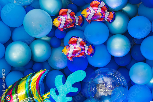 Marine-style decor of balloons  fish  and corals for the birthday photo zone.