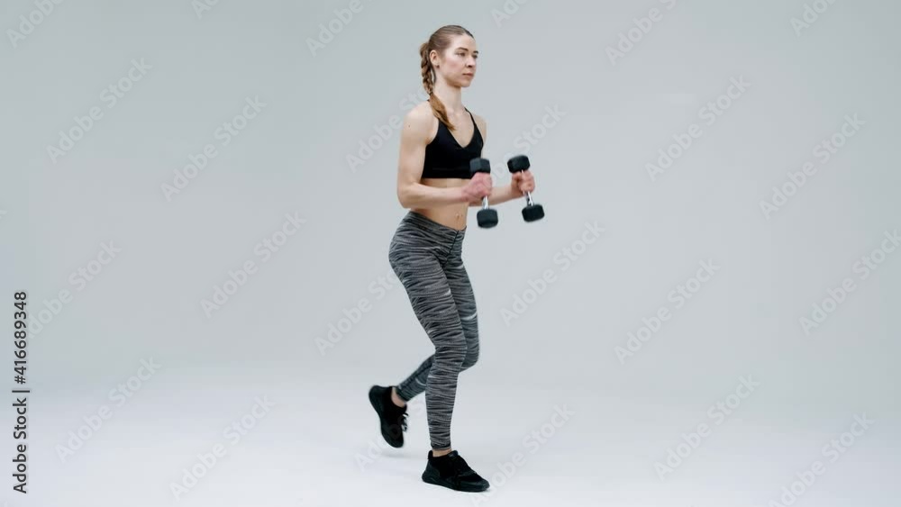 Young girl trainer performs squats and exercises with dumbbells. The girl is engaged in sports, fitness. Active lifestyle. Isolated on a white background Young girl trainer performs squats and exercises with dumbbells. The girl is engaged in sports, fitness. Active lifestyle. Isolated on a white background