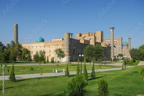 Landscape view of famous medieval Registan Square viewed from surrounding garden with Ulugh Beg madrassa in foreground, Samarkand, Uzbekistan