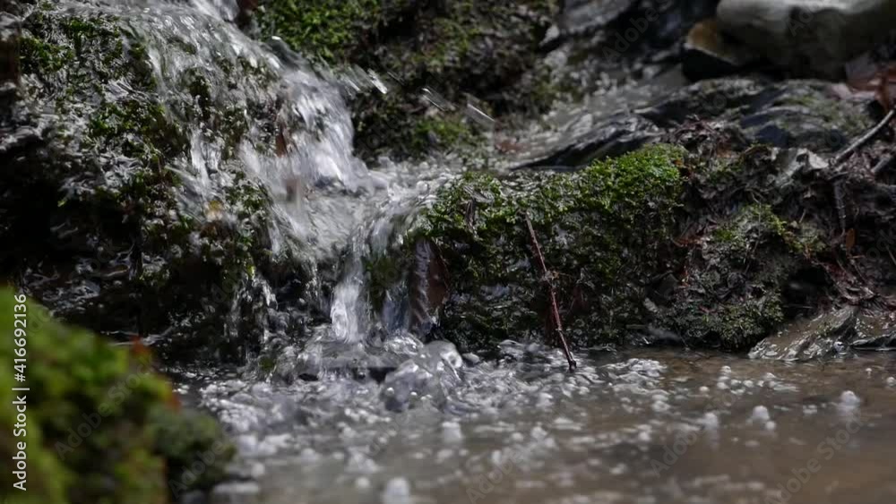 Purest mountain creek in the forest. Stream of water moves between the stones covered with moss. Idyllic green scenery with small river. Nature background series Purest mountain creek in the forest. Stream of water moves between the stones covered with moss. Idyllic green scenery with small river. Nature background series