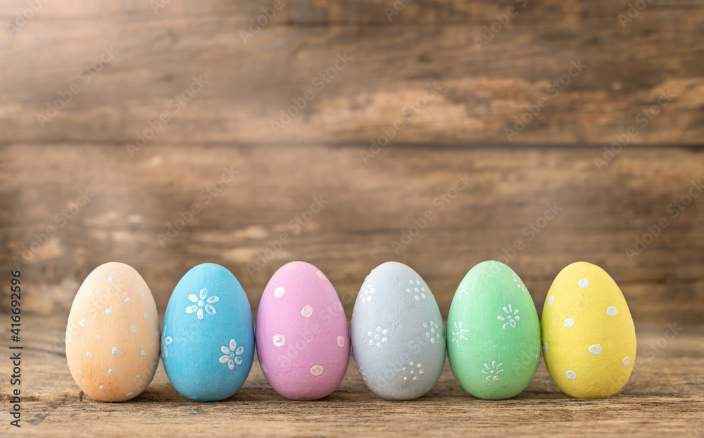 Painted Easter eggs arranged in a row on a wooden background
