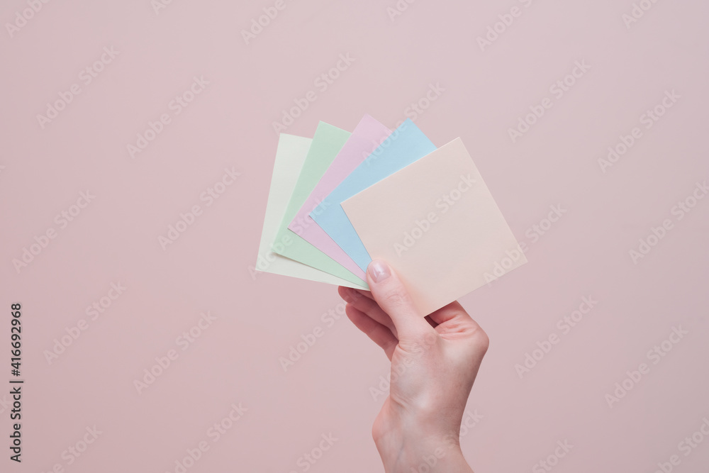 Female hand holding blank colourful sticky notes Female hand holding blank colourful sticky notes